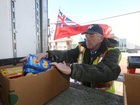 Alumni member Mike Hameluck loads food items into a box for transport to Churchill, the effort has been arranged by Blue Bombers Alumni Saturday.