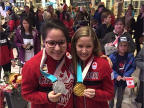 Pyeongchang Olympic Games women's hockey silver medallist Brigette Lacquette of Mallard, Man., and mixed doubles curling gold medallist Kaitlyn Lawes of Winnipeg show off their medals at the James Richardson International Airport on Monday, Feb. 26, 2018, where they were met by family and friends after returning from South Korea.