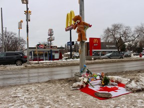 A memorial filled with stuffed animals, flowers and a Canadian flag sit at the foot of the pedestrian crosswalk where an eight-year-old boy was struck by a car and killed on his way to school on Feb. 13. On Tuesday, council's public works committee approved a plan to enhance lighting and visibility at the St. Anne's Road and Varennes Avenue crossing.