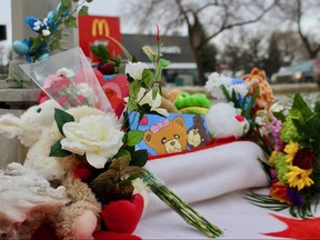A memorial filled with stuffed animals, flowers and a Canadian flag sit at the foot of the pedestrian crosswalk where an eight-year-old boy was struck by a car and killed on Tuesday morning in Winnipeg. 
Scott Billeck/Winnipeg Sun