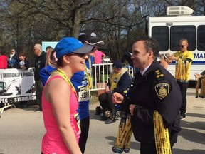 Police Chief Danny Smyth hands out medals at the finish line of the 13th annual Winnipeg Police Service Half Marathon on Sunday, May 7, 2017, at Assiniboine Park in Winnipeg.