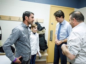 Emad Mishko Tamo, 13, meets with Prime Minister Justin Trudeau along with his uncle Haji Tamo, left, and the president of the Yazidi Association of Manitoba, Khalil Hesso in Winnipeg on Wednesday, in this handout photo.