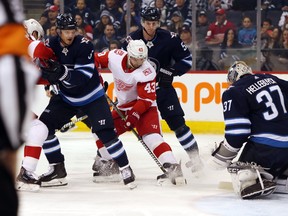 Red Wings’ Darren Helm holds his ground in front of Jets goaltender Connor Hellebuyck the Bell MTS Place Friday night. Brook Jones/Postmedia Network