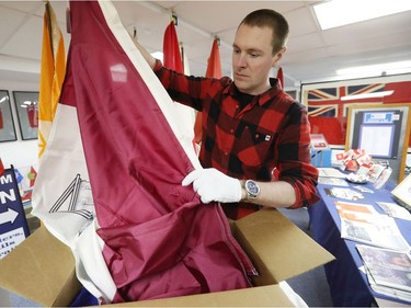 Shayne Campbell, who is the president and executive director of Settlers, Rails & Trails, looks at a McMaster University flag from the Ralph Spence collection which arrived at the local museum in Argyle, Man., located 50 kilometres northwest of Winnipeg, Man. on Friday, March 2, 2018. (Brook Jones/Stonewall Argus & Teulon Times/Postmedia Network)