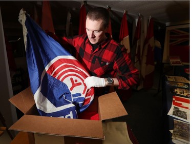 Shayne Campbell, who is the president and executive director of Settlers, Rails & Trails, shows off a United Way flag from the Ralph Spence collection which arrived at the local museum in Argyle, Man., located 50 kilometres northwest of Winnipeg, Man. on Friday, March 2, 2018. (Brook Jones/Stonewall Argus & Teulon Times/Postmedia Network)