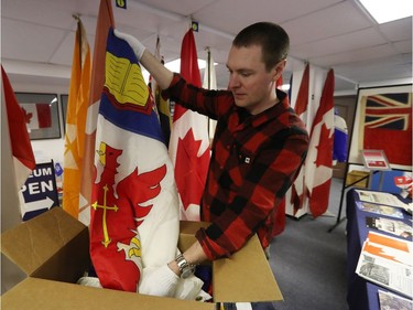 Shayne Campbell, who is the president and executive director of Settlers, Rails & Trails, looks at a flag from the Ralph Spence collection which arrived at the local museum in Argyle, Man., located 50 kilometres northwest of Winnipeg, Man. on Friday, March 2, 2018. (Brook Jones/Stonewall Argus & Teulon Times/Postmedia Network)