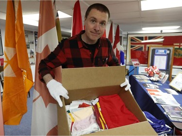 Shayne Campbell, who is the president and executive director of Settlers, Rails & Trails, opens one of seven boxes of flags from the Ralph Spence collection which arrived at the local museum in Argyle, Man., located 50 kilometres northwest of Winnipeg, Man. on Friday, March 2, 2018. (Brook Jones/Stonewall Argus & Teulon Times/Postmedia Network)