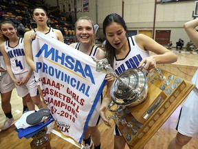 Oak Park Raiders forward Sam Courtney nearly drops the trophy after they beat the Vincent Massey Trojans in the 'AAAA' provincial high school basketball championship on Monday. (KEVIN KING/Winnipeg Sun)