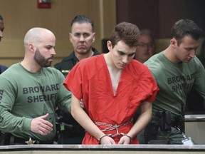 Nikolas Cruz is lead into the courtroom before being arraigned at the Broward County Courthouse in Fort Lauderdale, Fla., on Wednesday, March 14, 2018.