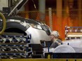 A line worker works on a car at Ford Motor plant in Oakville, Ont., on Jan. 4, 2013.