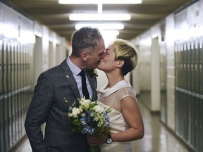 In this Saturday, March 10, 2018 photo, newlyweds Jenn Sudol and Chris Gash kiss as they are married in front of their old high school lockers at Clifton High School, in Clifton, N.J.