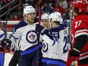 Jets forward Patrik Laine (29) celebrates his goal with teammates Nikolaj Ehlers (27) and Paul Stastny (25) during the first period against the Carolina Hurricanes on Sunday night. (The Associated Press)