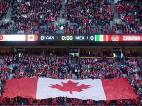 A large Canadian flag is held up by fans before Canada and Mexico play a FIFA World Cup qualifying soccer match in Vancouver, B.C., on Friday March 25, 2016. Vancouver is out of the running for the 2026 World Cup after the province failed to reach a deal with the North American bid committee.