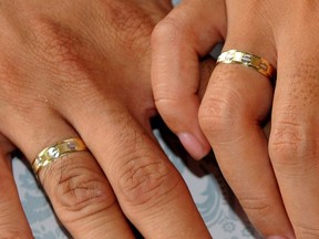 Photo taken October 10, 2010 shows a couple holding hands during a mass wedding of 250 couples in Manila. Qualified support for divorce is rising in the mainly Roman Catholic Philippines, the world's remaining holdout apart from the Vatican, according to an independent nationwide survey released on June 2, 2011.    AFP PHOTO / JAY DIRECTO