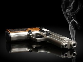Chromed handgun on black background with smoke