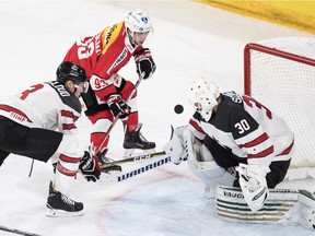 Switzerland's Lino Martschini, (center) in action against Canada's Zach Whitecloud (left) and goaltender Ben Scrivens during the 2017 Karjala Cup ice hockey match between Switzerland and Canada in Biel, Switzerland, last November.