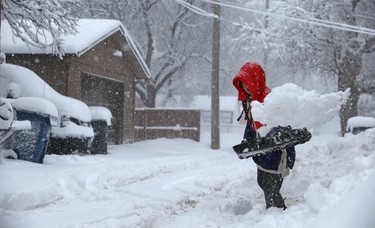 Olivia Ju clears snow from her driveway in the backlane near Harrow Street in Winnipeg on Mon., March 5, 2018. Kevin King/Winnipeg Sun/Postmedia Network