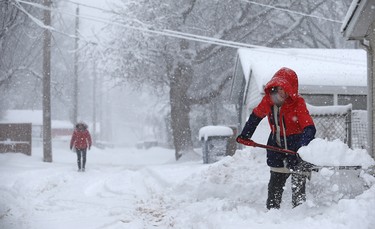 Olivia Ju clears snow from her driveway in the backlane near Harrow Street in Winnipeg on Mon., March 5, 2018. Kevin King/Winnipeg Sun/Postmedia Network