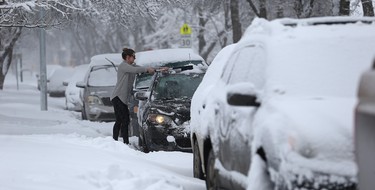 A residents clears a car of snow on Warsaw Avenue in Winnipeg on Mon., March 5, 2018. Kevin King/Winnipeg Sun/Postmedia Network