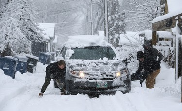 An attempt to free a stuck van in a backlane in the Crescentwood area of Winnipeg on Mon., March 5, 2018. Kevin King/Winnipeg Sun/Postmedia Network