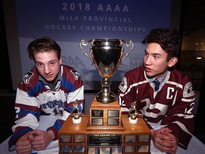 Captains Mack Whitely (left) of the Sturgeon Heights Huskies and Michael Lee of the St. Paul's Crusaders pose with the Don Barton Cup during a press conference at the Manitoba Sports Hall of Fame in Winnipeg on Tuesday.