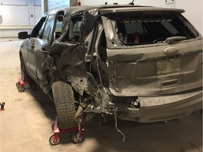 Damage to an unmarked Winnipeg Police Service vehicle is shown off at a press briefing at the police headquarters on Monday. The vehicle was involved in a three-vehicle collision on Sunday, which sent four people to hospital including the officer.