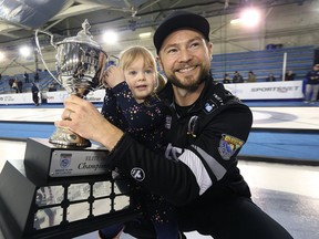 Mike McEwen and daughter Vienna pose with the trophy after defeating Brad Gushue in the final of the Gram Slam of Curling's Elite 10 event at the St. James Civic Centre in Winnipeg on Sun., March 18, 2018. Kevin King/Winnipeg Sun/Postmedia Network