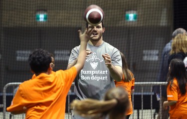 Calgary Stampeders linebacker Alex Singleton catches a pass from a student during a Jumpstart event at the RBC Convention Centre that is part of CFL Week in Winnipeg on Thurs., March 22, 2018. Over 150 kids from Greenway and Victory schools were able to participate in drills with current CFL stars. Kevin King/Winnipeg Sun/Postmedia Network