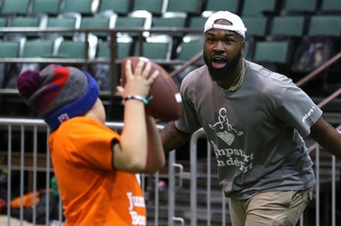 Hamilton Tiger-Cats linebacker Simoni Lawrence covers a student during a Jumpstart event at the RBC Convention Centre that is part of CFL Week in Winnipeg on Thurs., March 22, 2018. Over 150 kids from Greenway and Victory schools were able to participate in drills with current CFL stars. Kevin King/Winnipeg Sun/Postmedia Network