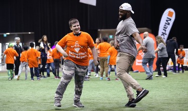 Hamilton Tiger-Cats linebacker Simoni Lawrence does a celebration dance with a student during a Jumpstart event at the RBC Convention Centre that is part of CFL Week in Winnipeg on Thurs., March 22, 2018. Over 150 kids from Greenway and Victory schools were able to participate in drills with current CFL stars. Kevin King/Winnipeg Sun/Postmedia Network