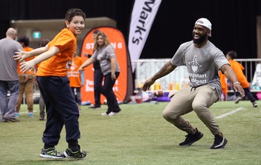 Hamilton Tiger-Cats linebacker Simoni Lawrence does a celebration dance with a student during a Jumpstart event at the RBC Convention Centre that is part of CFL Week in Winnipeg on Thurs., March 22, 2018. Over 150 kids from Greenway and Victory schools were able to participate in drills with current CFL stars. Kevin King/Winnipeg Sun/Postmedia Network