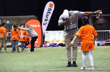 Hamilton Tiger-Cats linebacker Simoni Lawrence does a celebration dance with a student during a Jumpstart event at the RBC Convention Centre that is part of CFL Week in Winnipeg on Thurs., March 22, 2018. Over 150 kids from Greenway and Victory schools were able to participate in drills with current CFL stars. Kevin King/Winnipeg Sun/Postmedia Network