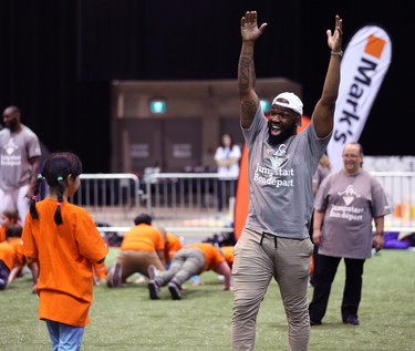 Hamilton Tiger-Cats linebacker Simoni Lawrence celebrates with a student during a Jumpstart event at the RBC Convention Centre that is part of CFL Week in Winnipeg on Thurs., March 22, 2018. Over 150 kids from Greenway and Victory schools were able to participate in drills with current CFL stars. Kevin King/Winnipeg Sun/Postmedia Network