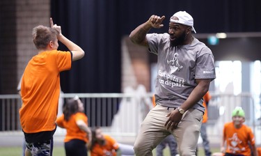 Hamilton Tiger-Cats linebacker Simoni Lawrence does a celebration dance with a student during a Jumpstart event at the RBC Convention Centre that is part of CFL Week in Winnipeg on Thurs., March 22, 2018. Over 150 kids from Greenway and Victory schools were able to participate in drills with current CFL stars. Kevin King/Winnipeg Sun/Postmedia Network