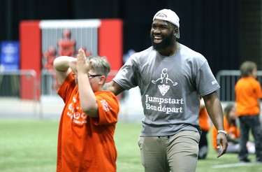 Hamilton Tiger-Cats linebacker Simoni Lawrence celebrates with a student during a Jumpstart event at the RBC Convention Centre that is part of CFL Week in Winnipeg on Thurs., March 22, 2018. Over 150 kids from Greenway and Victory schools were able to participate in drills with current CFL stars. Kevin King/Winnipeg Sun/Postmedia Network