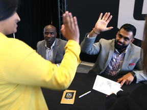 Former Winnipeg Blue Bombers Obby Khan, right, and Milt Stegall and Obby Khan interact with students during an autograph session at RBC Convention Centre in Winnipeg on Thurs., March 22, 2018 that is part of CFL Week. Kevin King/Winnipeg Sun/Postmedia Network