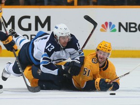Jets’ Brandon Tanev falls on the Predators’ Austin Watson during the third period in Game 2 of their series in Nashville last night.  Frederick Breedon/Getty images