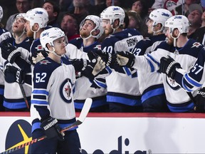 MONTREAL, QC - APRIL 03:  Jack Roslovic #52 of the Winnipeg Jets celebrates his second-period goal with teammates on the bench against the Montreal Canadiens during the NHL game at the Bell Centre on April 3, 2018 in Montreal, Quebec, Canada.  (Photo by Minas Panagiotakis/Getty Images)