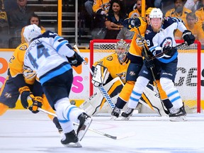 Goalie Pekka Rinne #35 of the Nashville Predators and Patrik Laine #29 of the Winnipeg Jets watch Josh Morrissey #44 take a shot during the first period in Game 1 Friday.