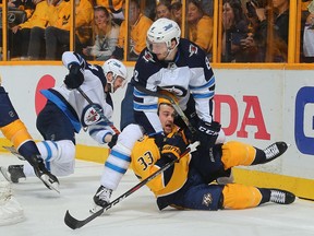 Jacob Trouba (8) of the Winnipeg Jets holds down Viktor Arvidsson (33) of the Nashville Predators during the first period in Game 2.