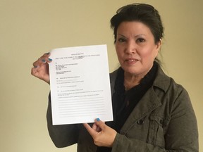 Coleen Rajotte holds up a Notice of Objection form, which is part of a national movement to oppose the Sixties Scoop Settlement agreement proposed by the Canadian government and prompt a renegotiation of the agreement. A Sixties Scoop survivor herself, Rajotte believes survivors deserve an approach more in line with that of residential school survivors.