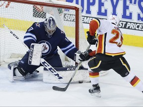 Winnipeg Jets goaltender Connor Hellebuyck (37) saves the breakaway attempt by Calgary Flames' Nick Shore (25) during first period NHL action in Winnipeg on Thursday, April 5, 2018. THE CANADIAN PRESS/John Woods ORG XMIT: JGW102