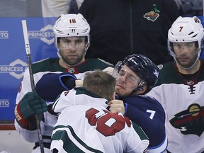 Winnipeg Jets' Ben Chiarot (7) and Minnesota Wild's Nick Seeler (36) mix it up during third period Game 2 NHL playoff action in Winnipeg on Friday.