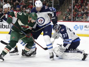 Jets' defenceman Tyler Myers (57) battles with Minnesota Wild left wing Marcus Foligno (17) in front of Winnipeg Jets goalie Connor Hellebuyck (37) in the first period of Game 3 on Sunday. Myers declared himself good to go for Game 5 Friday after missing Game 4 with an injury.