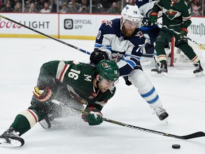 Jason Zucker  of the Minnesota Wild controls the puck against Joe Morrow of the Winnipeg Jets during Game 4 at Xcel Energy Center on April 17, 2018 in St Paul, Minnesota. (Hannah Foslien/Getty Images)
