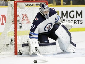 Winnipeg Jets goalie Connor Hellebuyck blocks a shot from the Nashville Predators during the second period in Game 1 of an NHL hockey second-round playoff series Friday, April 27, 2018, in Nashville, Tenn. (AP Photo/Mark Humphrey) ORG XMIT: TNMH121