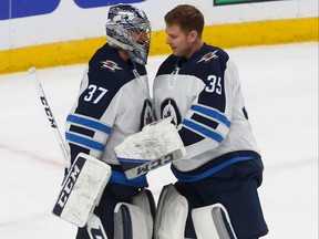 Winnipeg Jets goalie Connor Hellebuyck (left) is congratulated by goalie Steve Mason after Hellebuyck shut out the Minnesota Wild 2-0 in Game 4 of Round 1.