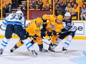 The Jets’ Dustin Byfuglien (left) and Toby Enstrom (right) battle with Craig Smith (second from left) and Kevin Fiala for a bouncing puck at Bridgestone Arena in Nashville, Tenn., last night.(Getty Images)