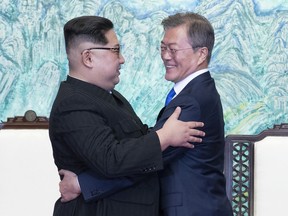 North Korean leader Kim Jong Un, left, and South Korean President Moon Jae-in embrace each other after signing on a joint statement at the border village of Panmunjom in the Demilitarized Zone, South Korea, Friday, April 27, 2018.