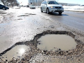 Traffic moves past potholes in Winnipeg.